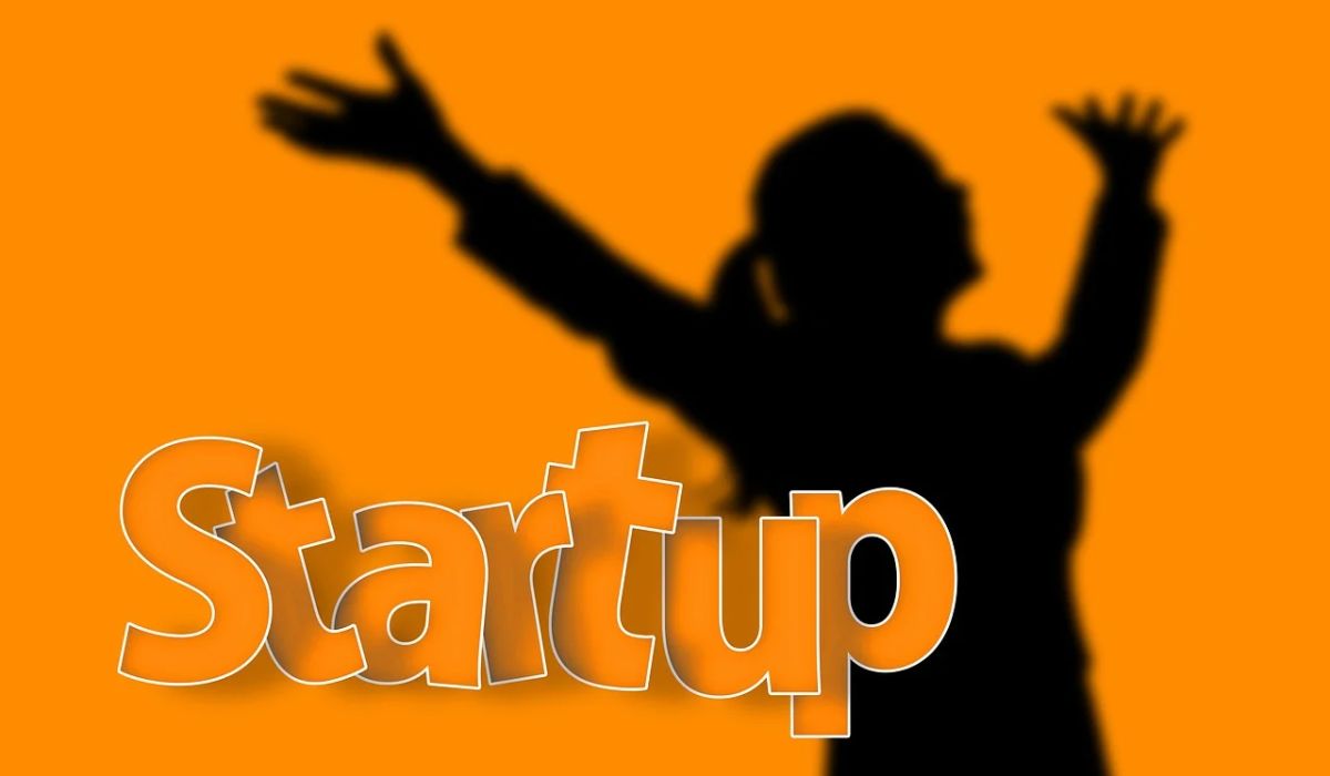 A women startup owner with a orange background and startup written in orange color font