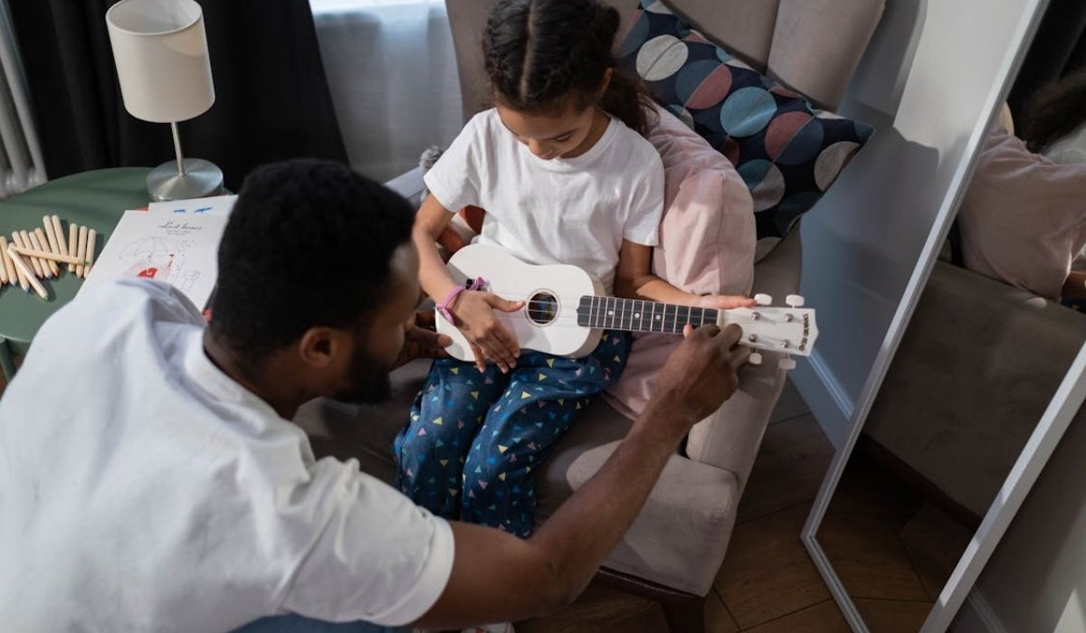 A music teacher teaching guitar to a student