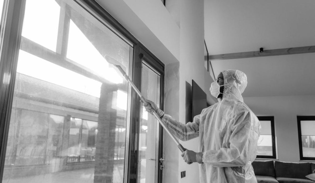 An employee of a cleaning company, cleaning a glass window