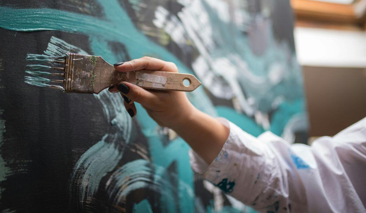 A person painting color with a brush on a wall