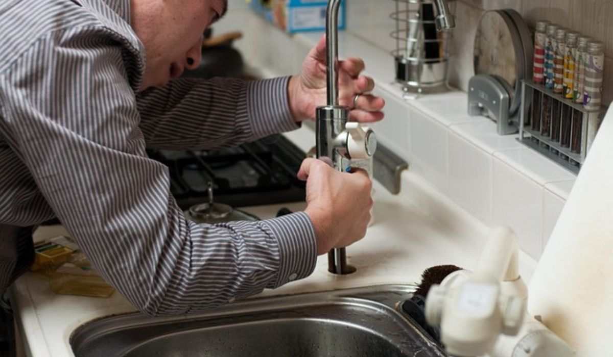 A person performing plumbing job