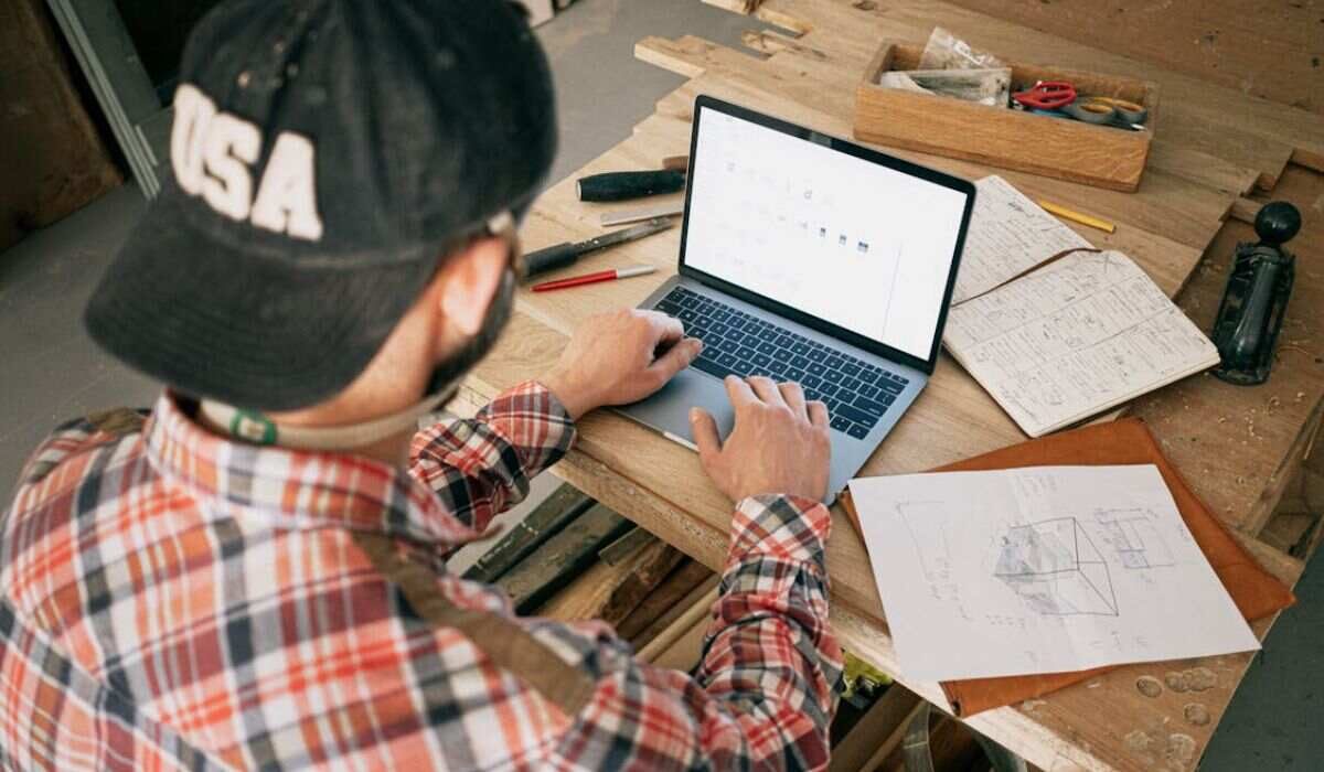 A handyman creating an invoice on his laptop