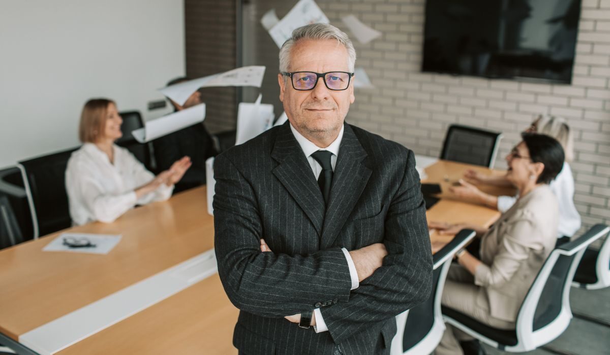 A old man standing with crossed arms.
