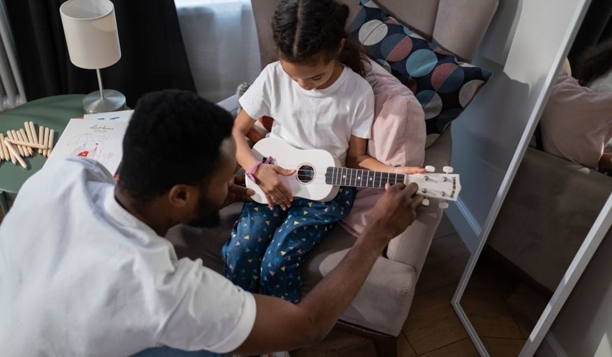 A music teacher teaching guitar to a student