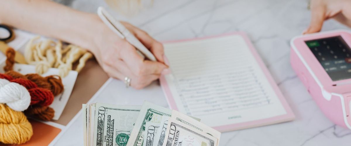Woman estimating with a pen, book, calculator