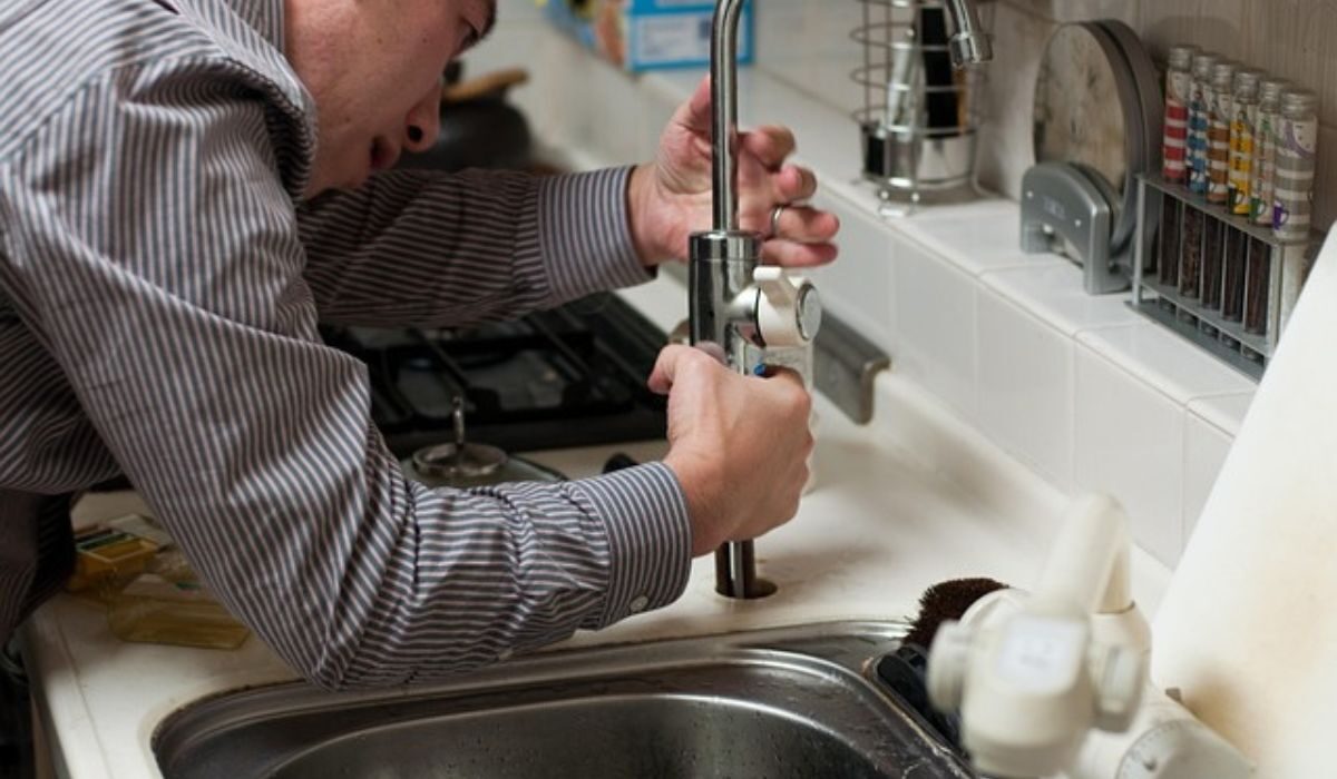 A person performing plumbing job