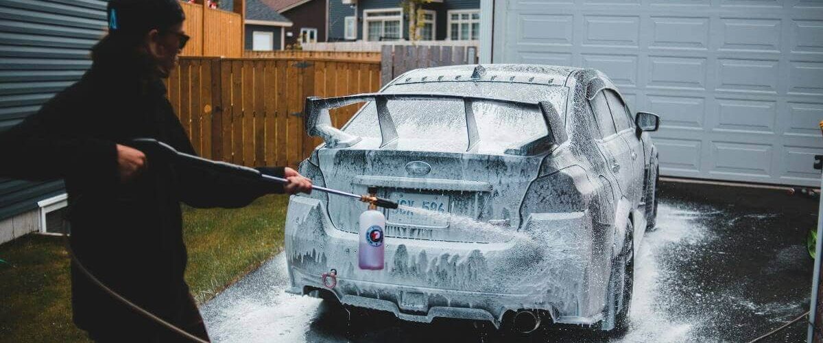 A person power washing car