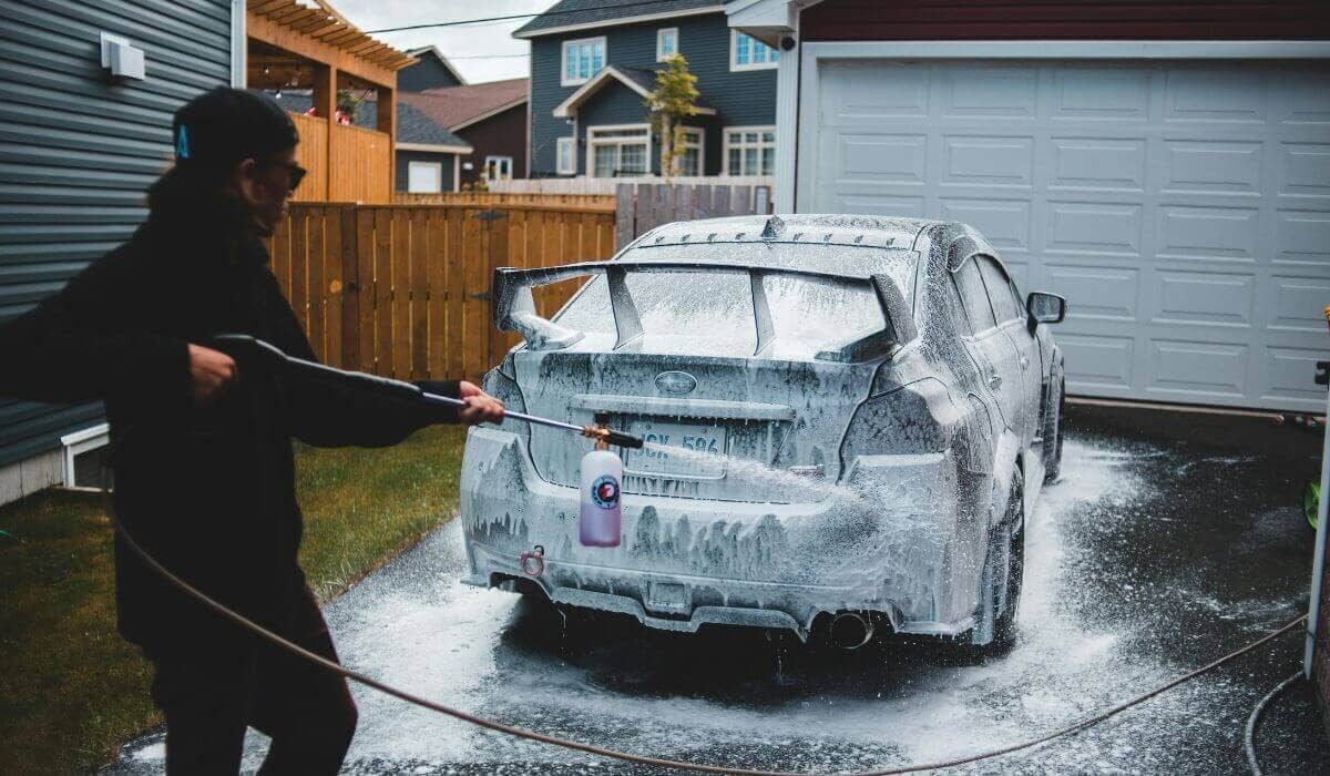 A person power washing car